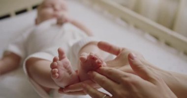 Baby feet in mother hands. Tiny Newborn Babys feet on female Heart Shaped hands closeup. Happy Family concept. Baby foots close-up. Mother enjoying motherhood checks baby health. Feet heart shape.