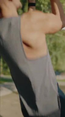 A muscular man doing a pull-up on outdoor fitness equipment, showcasing strength and determination. The setting is a sunny day in a park, emphasizing an active lifestyle. Performing Pull-Up Exercise