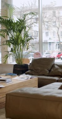 Modern Board Shop Interior with Comfortable Seating and City View. Natural Light Fills the Room, Creating a Relaxing Atmosphere for Customers. A Place to Unwind, Browse, Skateboarding Community.