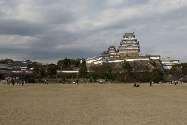 28-mar-2019 - HYOGO, JAPÓN: Castillo de Himeji y muchas capas de muros de piedra vistas desde lejos, Kan — Foto de Stock