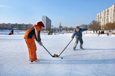 Kiev, Ukrayna, 19.02.2012 hokey sopaları ve bir çamaşır makinesi ile bir pisti üzerinde iki çocuk oyun hokey