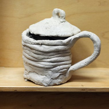 gri el yapımı, ahşap arka plan üzerinde izole kapak ile kil Kupası basık