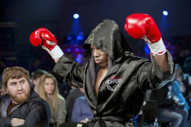 Brovary. Ukrayna, profesyonel bir boksör Anyanva siyah bir boks robe hood ve kırmızı boks eldiven boks maçtan önce kaldırdı elleri ile 14.11.2015