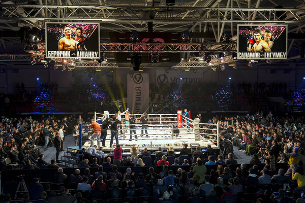 Brovary. Ukraine, 14.11.2015 Photographers take photos of boxing winner on the boxing ring. Scoreboards with annonce of the match are over the boxing ring