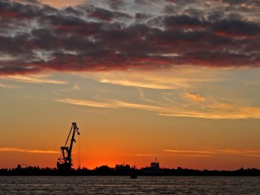 Sunset Bulvarında bir siluet vinç banka ile nehir