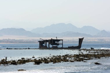Dağların fon batık bir geminin paslı kalıntıları