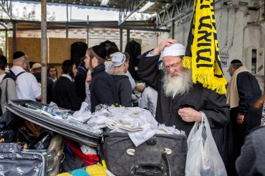 Uman, Ukrayna, 13.09.2015: Arka plan üzerine açık bavul şeylerden bir sürü Yahudi erkek dolu yakınındaki eski Yahudi adam standları vardır