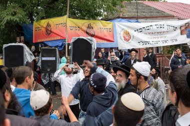 Uman, Ukrayna, 13.09.2015: Kipa ve siyah elbiseli Yahudi erkekler gülen ve sokakta fotoğraf çekme