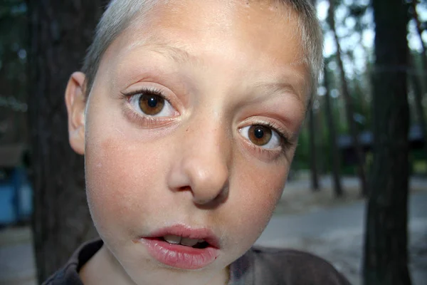 一転でカメラのレンズに見える大きな目をした小さな男の子の顔 — ストック写真