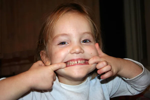 Hravá Holčička Ukazuje Zuby Pohybující Sebe Její Tváře Prsty — Stock fotografie