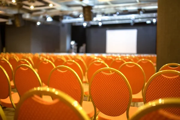 Auditorio Vacío Con Sillas Naranjas Frente Escenario Con Una Pantalla —  Fotos de Stock