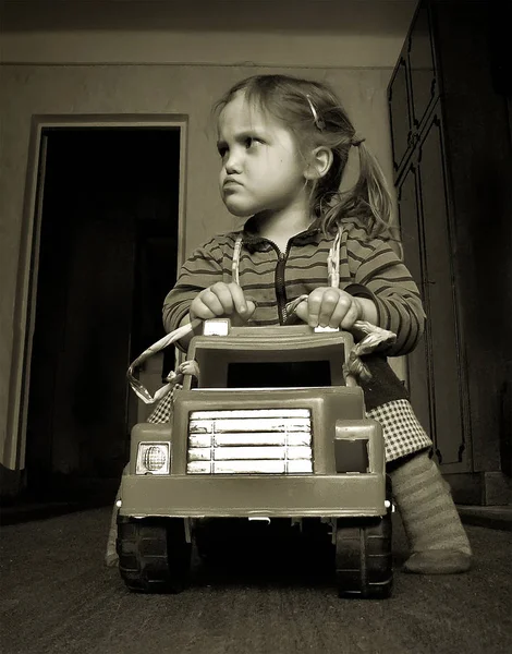深刻な顔をしかめるとおもちゃの車の女の子 — ストック写真