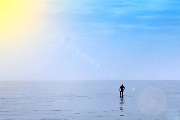 Silueta Muže Který Stojí Uprostřed Moře Vlnolamu Slunce Osvětluje Mořskou — Stock fotografie