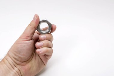 Beyaz arka planda büyük bir demir ceviz tutan bir erkek el..