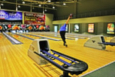 Bowling salonunun bulanık görüntüsü. Sporcu topu atar. Arkaplan dokusu.