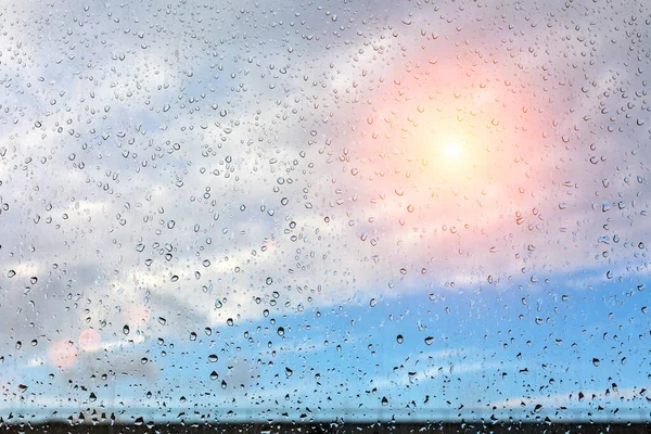 Hujan Menetes Jendela Yang Tertutup Kaca Terhadap Langit Biru Matahari — Stok Foto