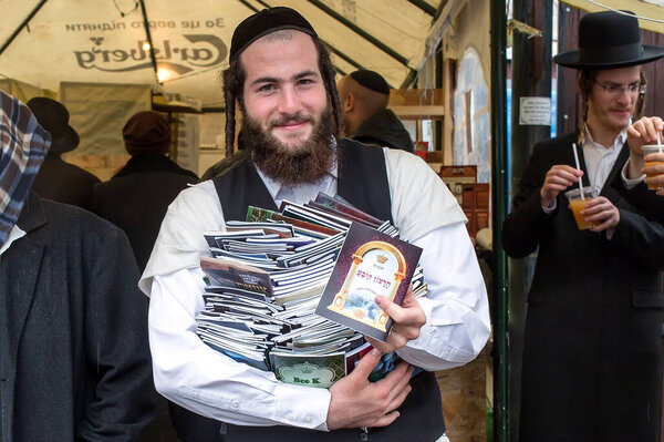 Uman,Ukraine, 13.09.2015: Jewish man with a pile of books in his outdoors hands