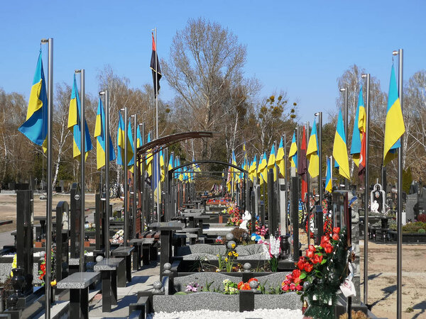 06.04.2020 Kiev Ukraine Cemetery of Ukrainian soldiers who died in the war in the Donbass. Rows of graves with Ukrainian flags.