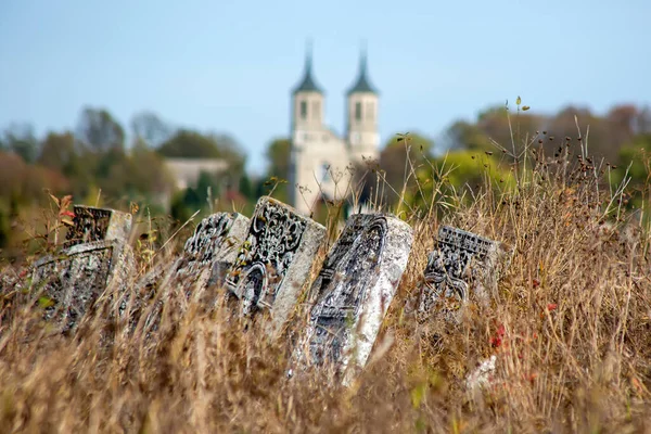 Old Jewish cemetery in the fall. Tombstones on a background of dry grass in a cemetery. The Jewish cemetery is a kirkut in the urban-type village of Satanov of Ukraine.