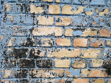 Üzerinde boya kalıntıları olan eski tuğla bir duvar. Arkaplan dokusu kapat.