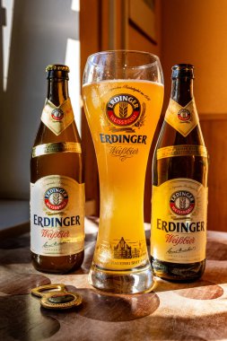 Erdinger birası markalı bir bira bardağına ve iki şişe biraya doldurulur. Erdinger birası masada. 04.07.2015 Kiev Ukrayna