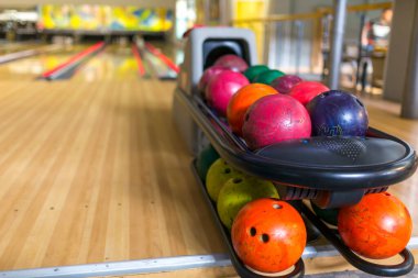 Kulüpteki bir grup renkli bovling topunu yakın plan çek. Bowling salonlarının arka planında