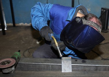 Kaynak. Elektrik yayı kaynaklama. İşçi iki demir köşesini kaynaklıyor..