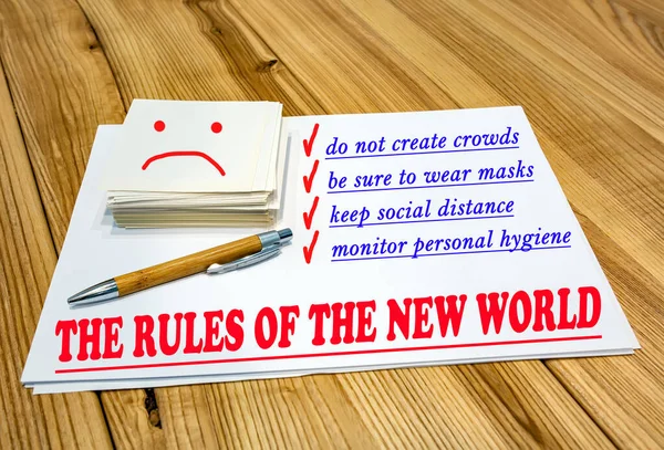 Life after quarantine is written on paper: do not create crowds, wear masks, maintain social distance, and monitor personal hygiene. Life after a pandemic. Pen and a stack of papers on the table.