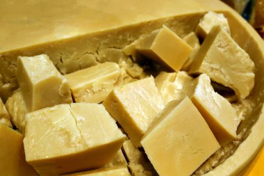 Peynir çemberinin içinde dilimlenmiş parmesan peyniri. Satılık. Dükkan vitrininde. Yıllanmış peynir.