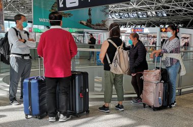 05.03.2020 Roma: Tıbbi maskeli insanlar uçağa binmek için sırada bekliyorlar. Coronavirus salgını sırasında havaalanında turistler.