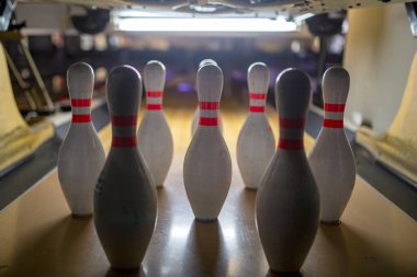 Beyaz bovling lobutları ve bowling salonunda turuncu bir top. Yakın plan. Arka plan.