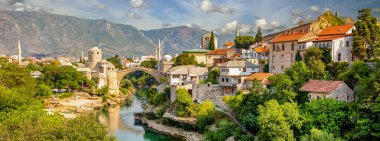 Bosna-Hersek 'teki Panorama Mostar köprüsü. Mostar şehrinde bir köprüsü ve zümrüt bir nehri olan renkli bir manzara. panoramik