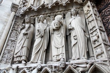 Aziz Denis başını tutuyor. Notre Dame de Paris 'in sol kapısındaki heykel. Kelle uçurma. İmparator Konstantin 'in heykelleriyle Meryem Ana' nın geçidi, Aziz Denis başını ve melekleri tutuyor.
