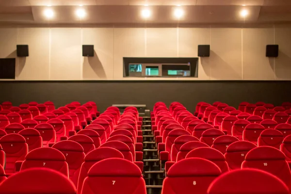 Empty cinema with red-black rows of seats. Empty red cinema hall seats, chairs. Perspective view 08.03.2019 Brovary, Ukraine