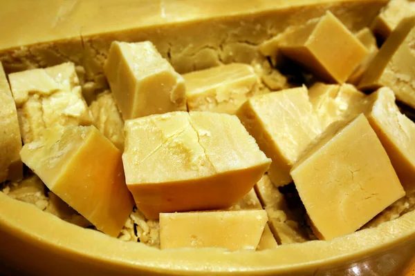 Peynir çemberinin içinde dilimlenmiş parmesan peyniri. Satılık. Dükkan vitrininde. Yıllanmış peynir.