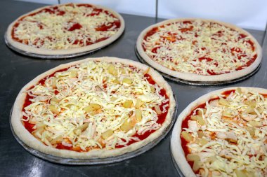 Aşçı mutfakta, pizzanın malzemelerini koyuyor. Pizza ham konsepti
