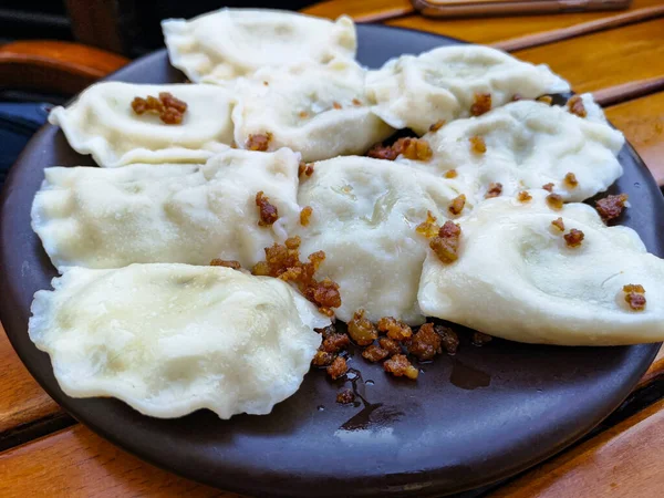 Dumplings Cracklings Dark Plate Wooden Table Close National Ukrainian Dish — Stock Photo, Image