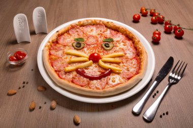 Pepperoni çocuk pizzası gülen surat salamı, mozzarella sosu, kiraz domatesleri, salatalık, patates kızartması, ketçap, fesleğen.