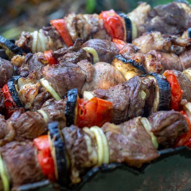Izgarayı şiş kebap ile yakın plan çek. Shashlik shashlyk. Şişler doğada, açık havada soğan, domates ve patlıcanla şişlenmemiş..