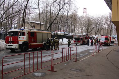 Firefighters stand near the building in Moscow / Firefighters stand near the building during the exercises EMERCOM of Russia in Moscow, March 21, 2018 clipart