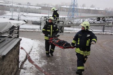 İtfaiyeciler yanmış bir manken taşımak / 19 Aralık 2017 Moskova'da binada eğitim yangın