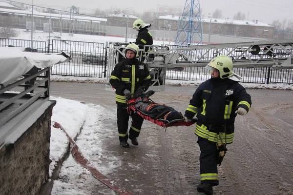 İtfaiyeciler yanmış bir manken taşımak / 19 Aralık 2017 Moskova'da binada eğitim yangın