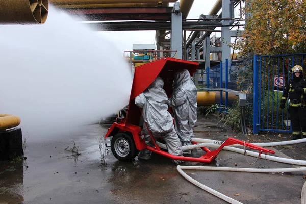 Isı yansıtıcı takım elbiseli iki itfaiye zırhlı kalkanı çalışma / felaket Termik Santrali'nde 5 Ekim 2016 yılında Moskova'da eğitim.