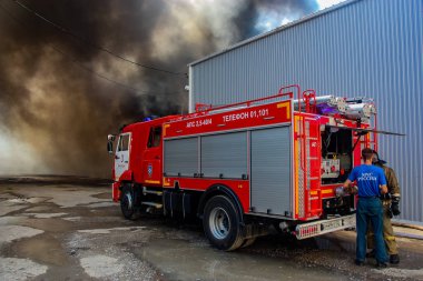 Krasnodar 'da bir depoda bir yangının arka planında Rusya 'nın yangın kamyonu Emercom