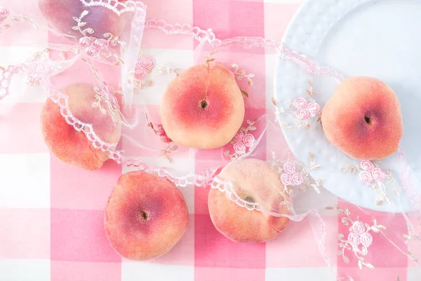 Flache Pfirsiche Auf Zartem Rosa Hintergrund Mit Spitze Und Weißem — Stockfoto