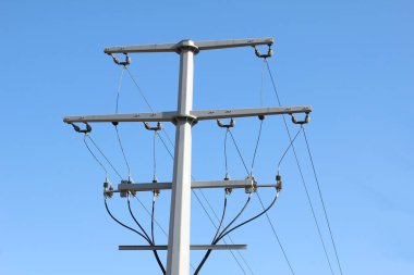 Mavi gökyüzünün arkaplanındaki iletim hattı.