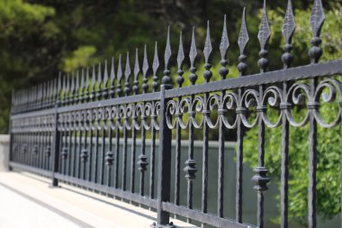 Metal çit. Parkta metal kıvrımlı çitler
