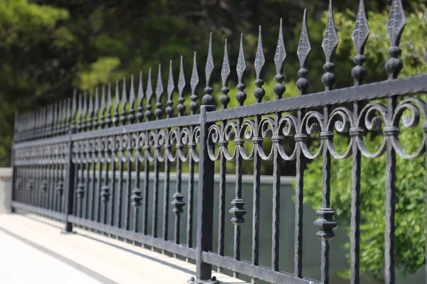 Metal çit. Parkta metal kıvrımlı çitler
