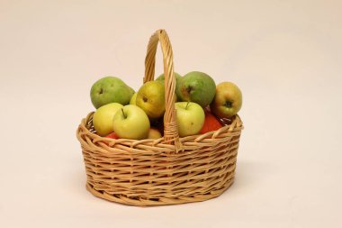 Hasır sepet beyaz arka plan üzerinde izole elma yığını ile