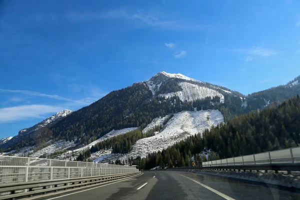 穿过高地的道路 背景是雪山 — 图库照片